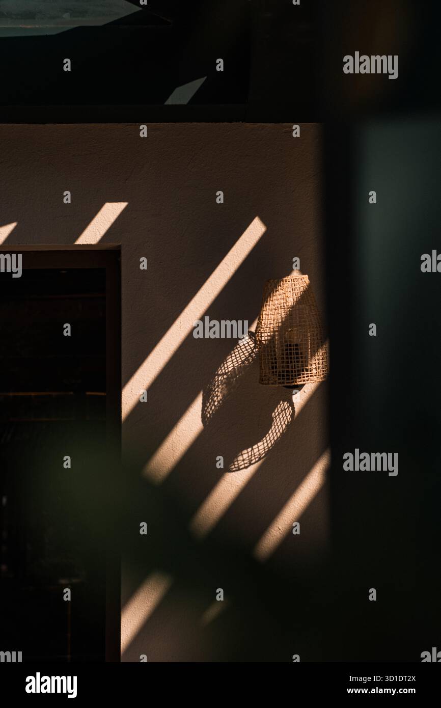 Motif abstrait de lumière et d'ombre sur un mur. La forte lumière du soleil diagonale crée des lignes graphiques et du contraste. Détail architectural minimaliste. Banque D'Images