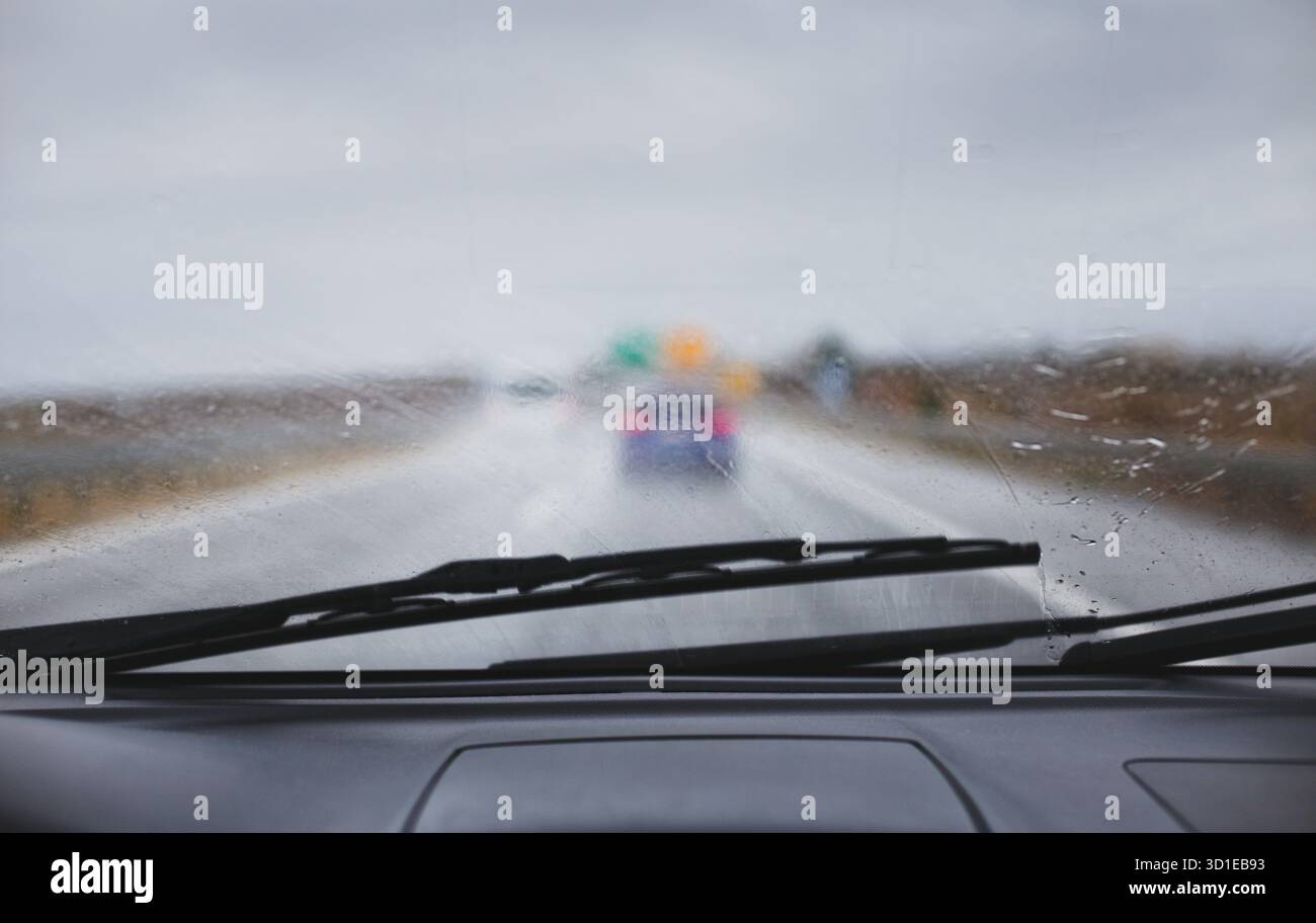 Voiture conduisant par mauvais temps pluie pare-brise laisse tomber l'eau sur la route Banque D'Images