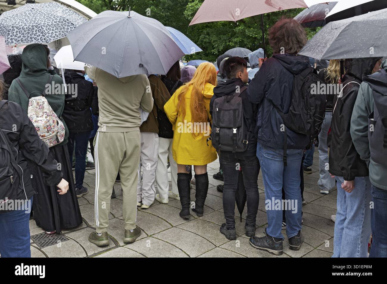 Jeunes spectateurs avec des parapluies dans la vue arrière, femme avec veste de pluie jaune vif entre les deux, Japan Day Duesseldorf, Rhénanie du Nord-Westphalie, Allemagne Banque D'Images