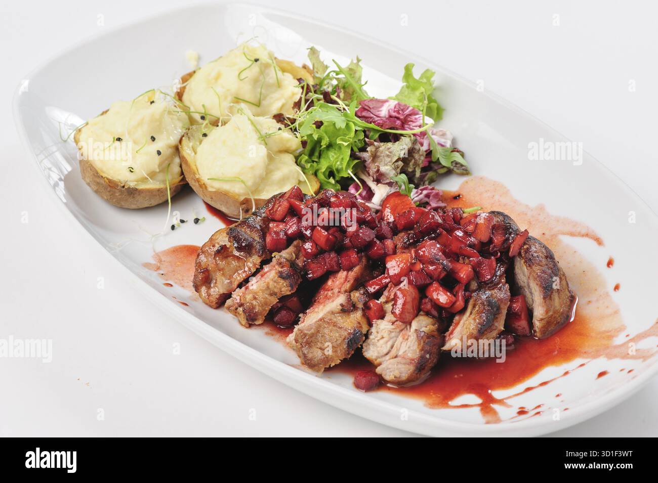 Tranches de bœuf rôti avec sauce aux baies, aux pommes et aux poires, pommes de terre et salade verte Banque D'Images
