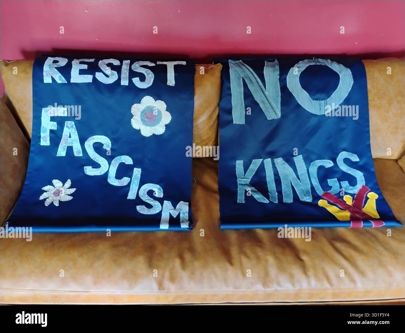Bannières de protestation politiques audacieuses et bleues cousues à la main affichant les messages Résistance au fascisme avec des symboles de fleurs stylisés et Pas de rois avec une couronne stylisée Banque D'Images
