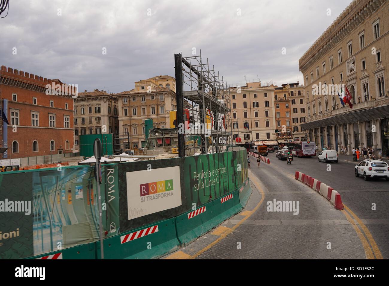 Paysage urbain avec une rue courbe, des bâtiments historiques et la zone de construction clôturée de la ligne C du métro. Mélange d'architecture ancienne et de développement. Banque D'Images