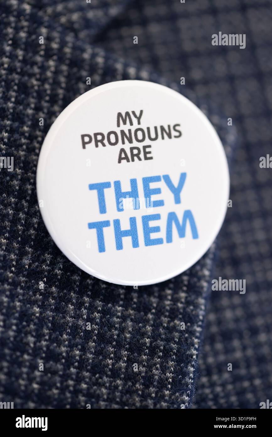 Un badge portant les mots « My pronoms are They » est porté sur le revers d'un blazer bleu Banque D'Images