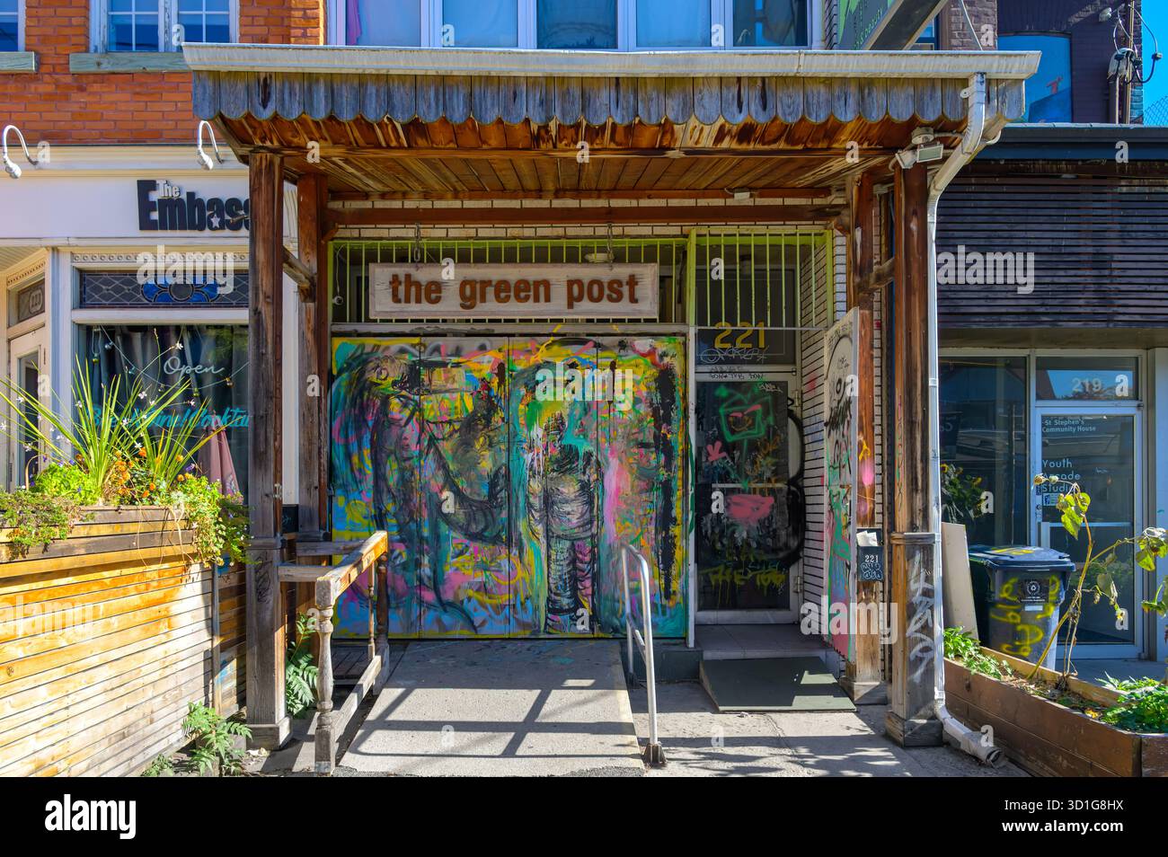 Entrée colorée couverte de graffitis du Green Post avec encadrement en bois et plantes dans le marché de Kensington. Banque D'Images