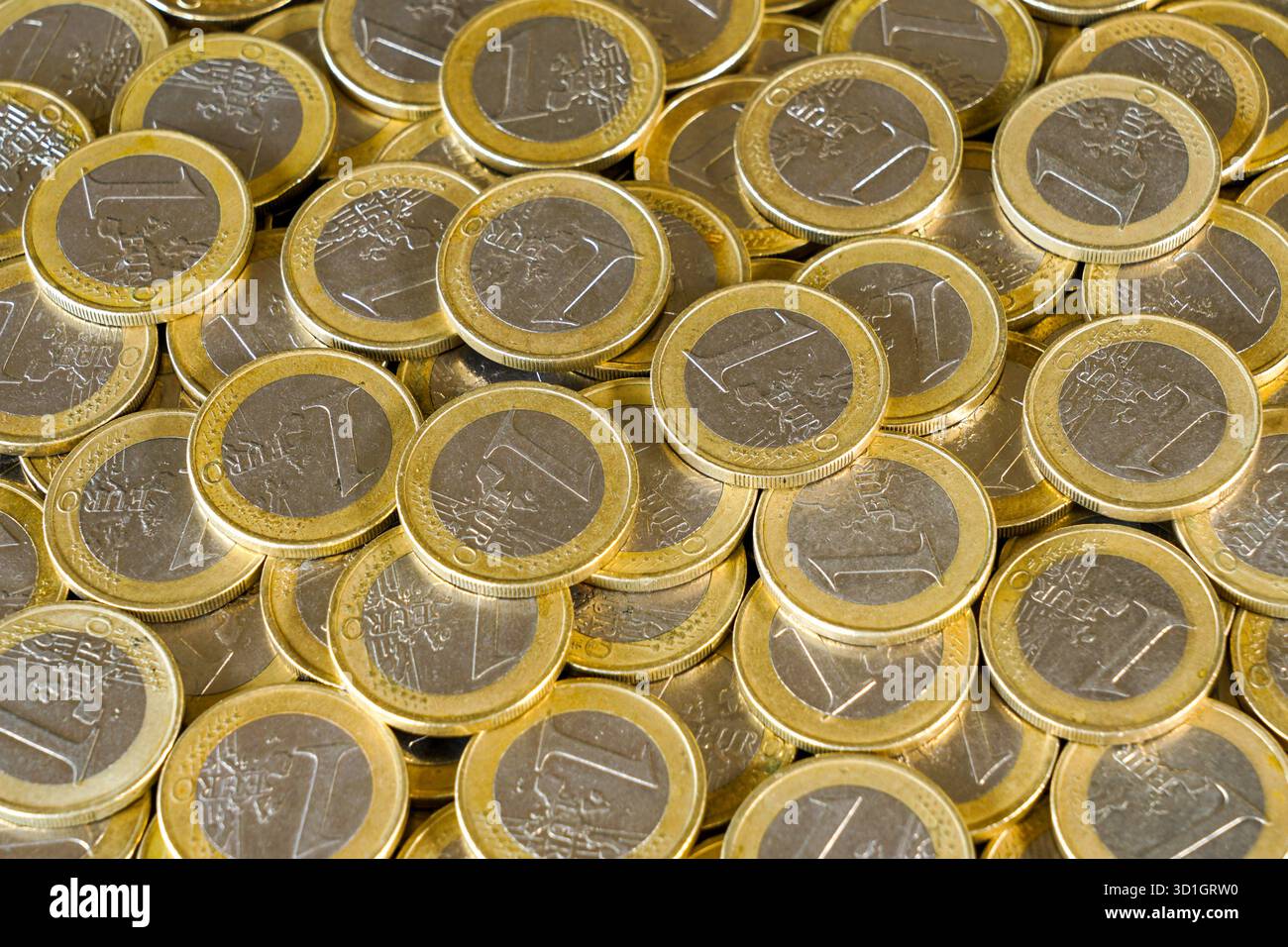 Pièces d'un euro, dispersées et empilées, représentant la monnaie européenne, l'économie, l'épargne, les services bancaires, et la stabilité financière dans la zone euro Banque D'Images