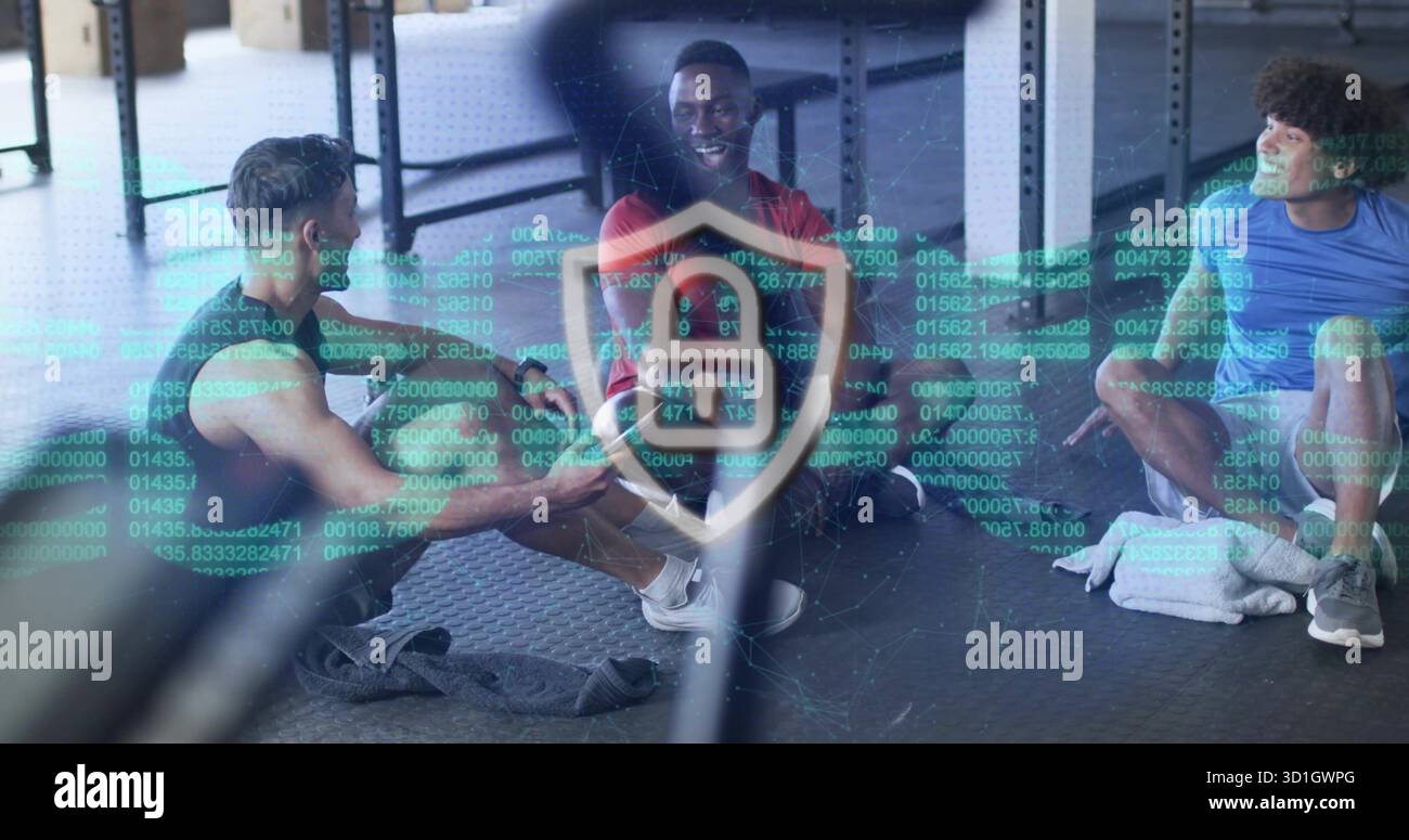 Hommes riant projetant la superposition de bouclier de verrouillage binaire à la salle de gym tout en étant assis sur des tapis, avec des haltères Banque D'Images