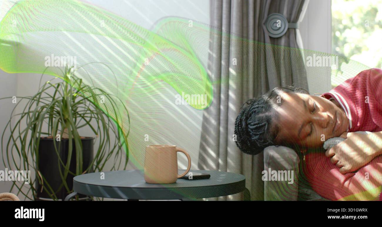 Femme inclinable portant un haut rouge à manches longues sur le canapé du salon, avec smartphone mug, espace copie Banque D'Images