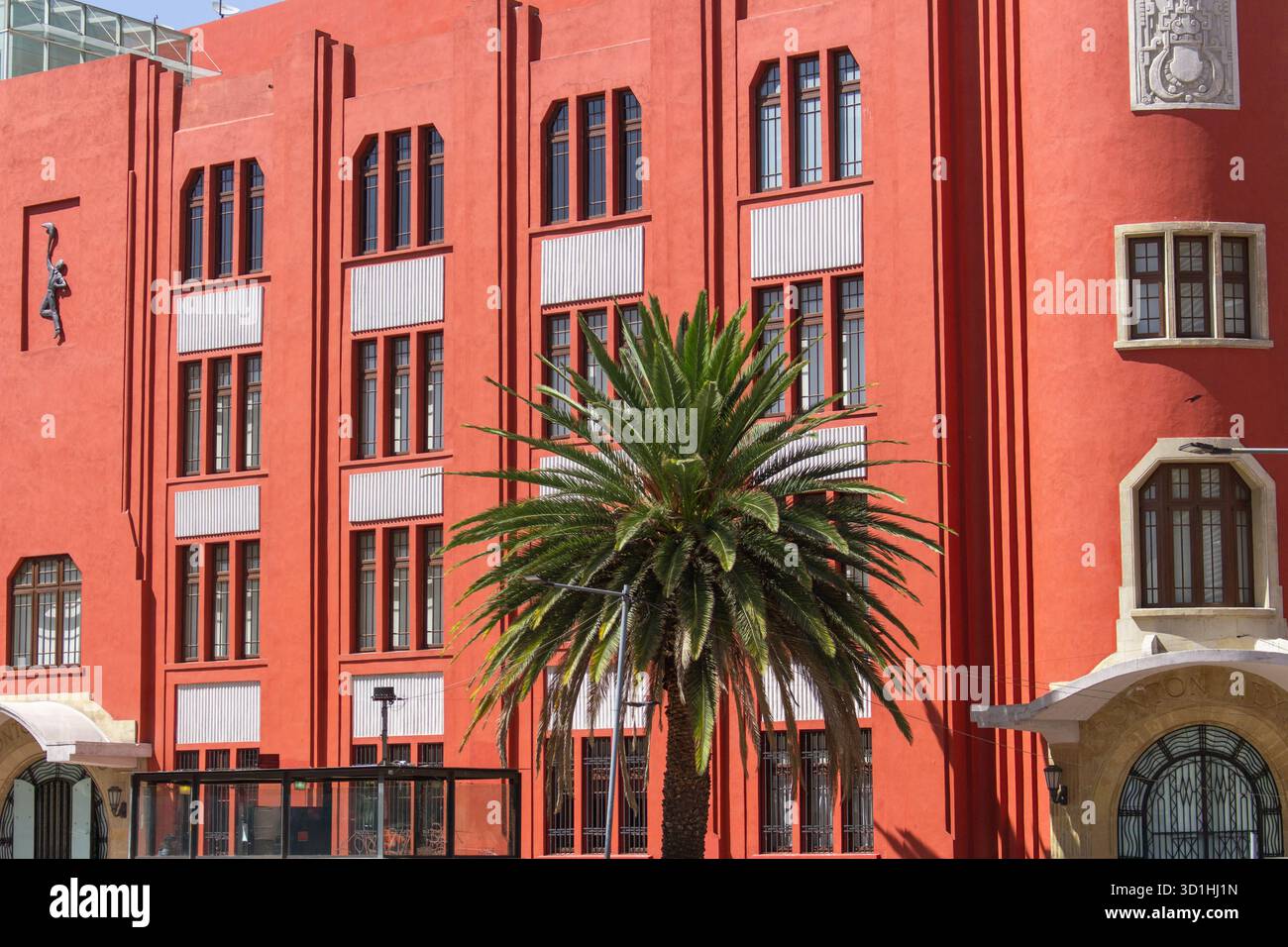 Bâtiment Art déco rouge vif avec palmier à Mexico - architecture géométrique et façade moderniste sous la lumière du soleil Banque D'Images
