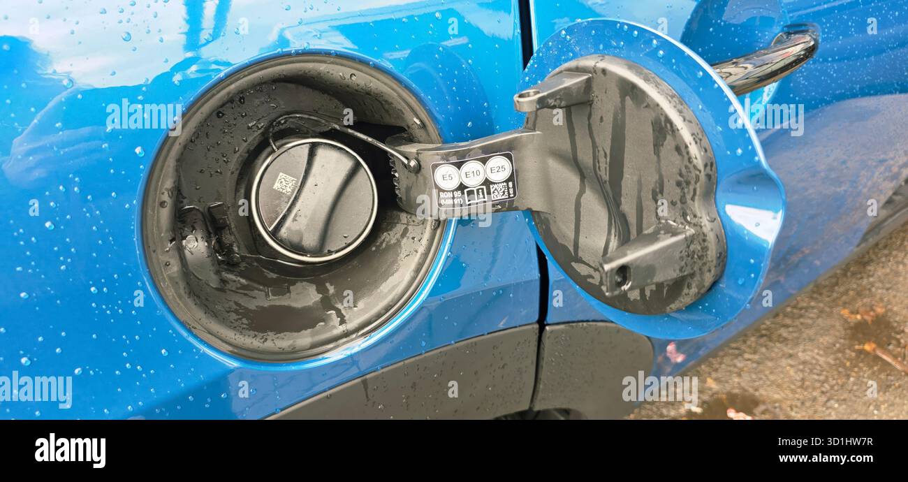 Berlin, Allemagne - 18 mai 2025 : le bouchon de carburant bleu du véhicule est ouvert, révélant une buse de gaz avec des gouttelettes de pluie sur la surface. - Image de stock capturée avec un smartphone