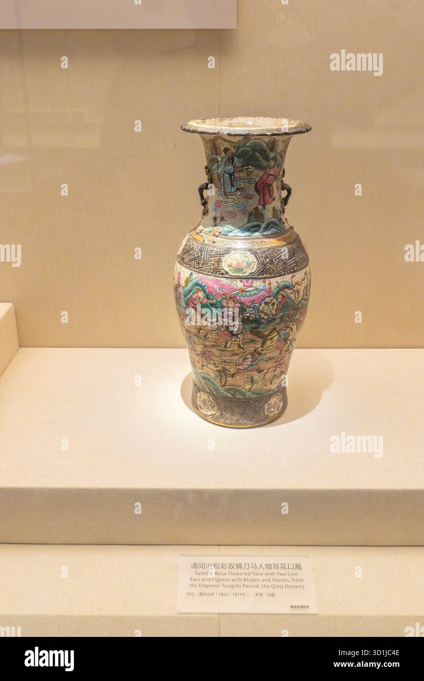 XiaPu Fujian Chine-14 août 2025 : vase fleuri famille-Rose avec deux oreilles de lion et des figures avec des lames et des chevaux, de la période de l'empereur Tongzhi, Banque D'Images
