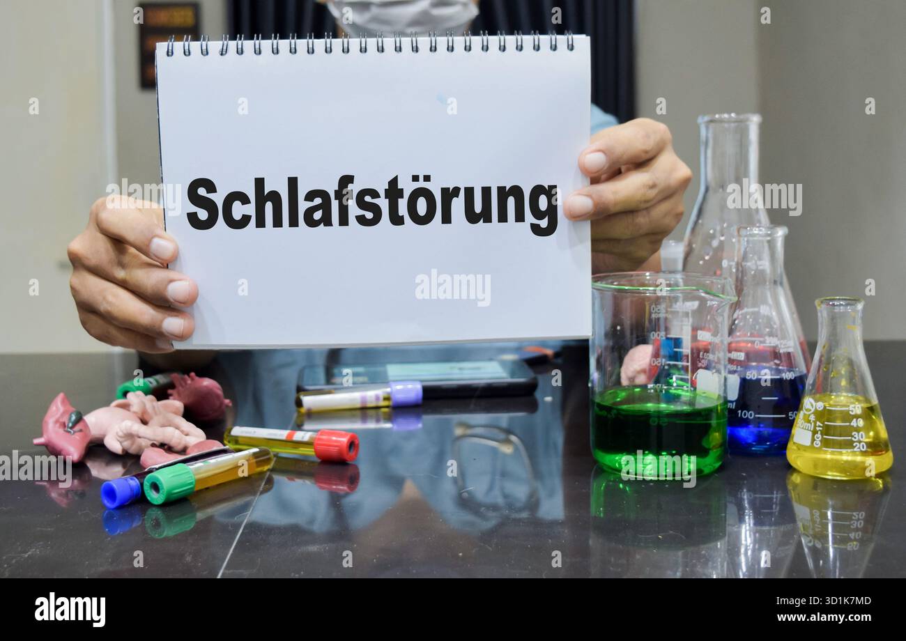 Un technicien de laboratoire souligne schlafstorung en allemand cela signifie trouble du sommeil sur un livre. concept de recherche scientifique Banque D'Images