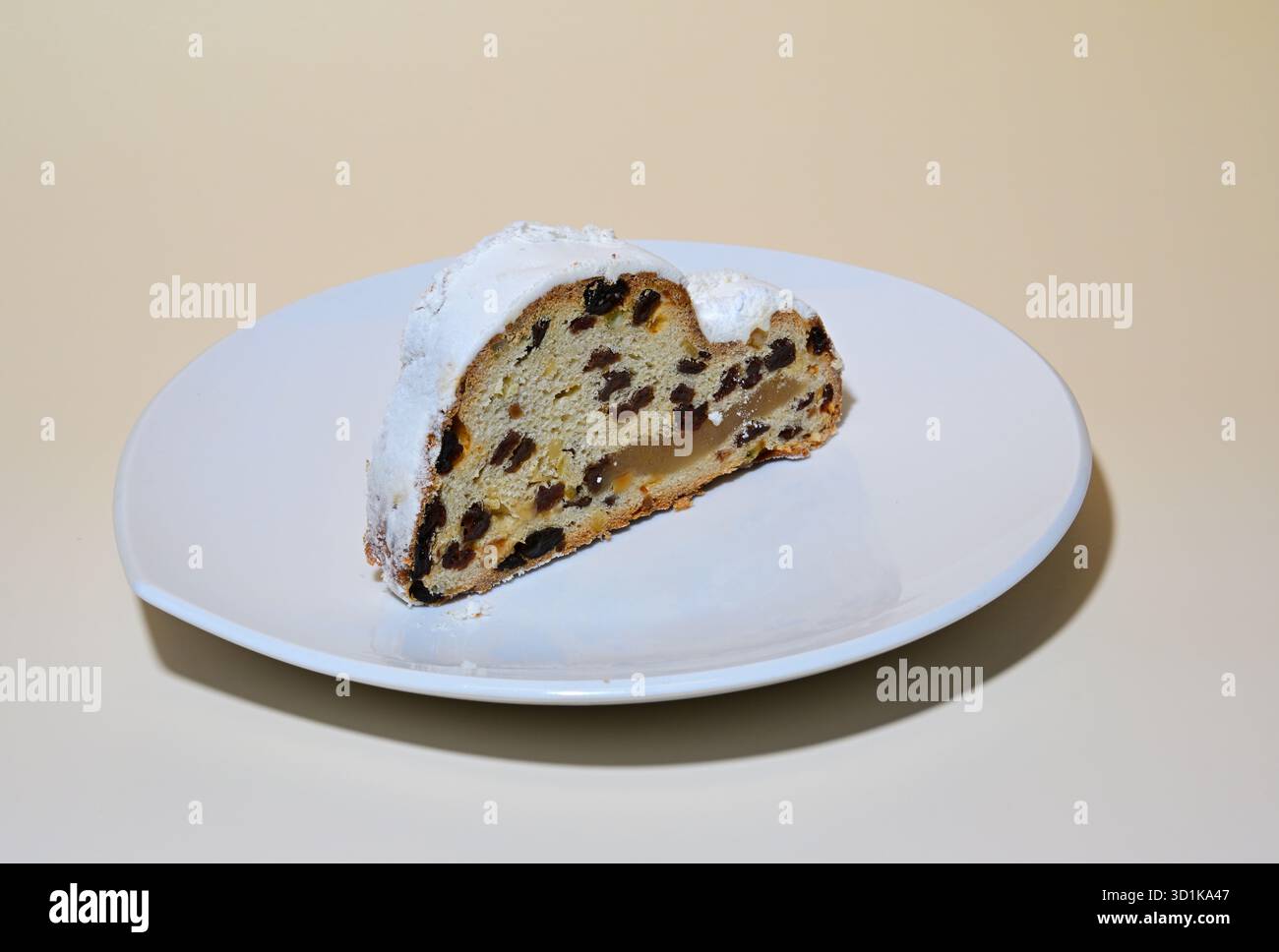 Stollen de Noël sur une assiette blanche sur un fond coloré Banque D'Images