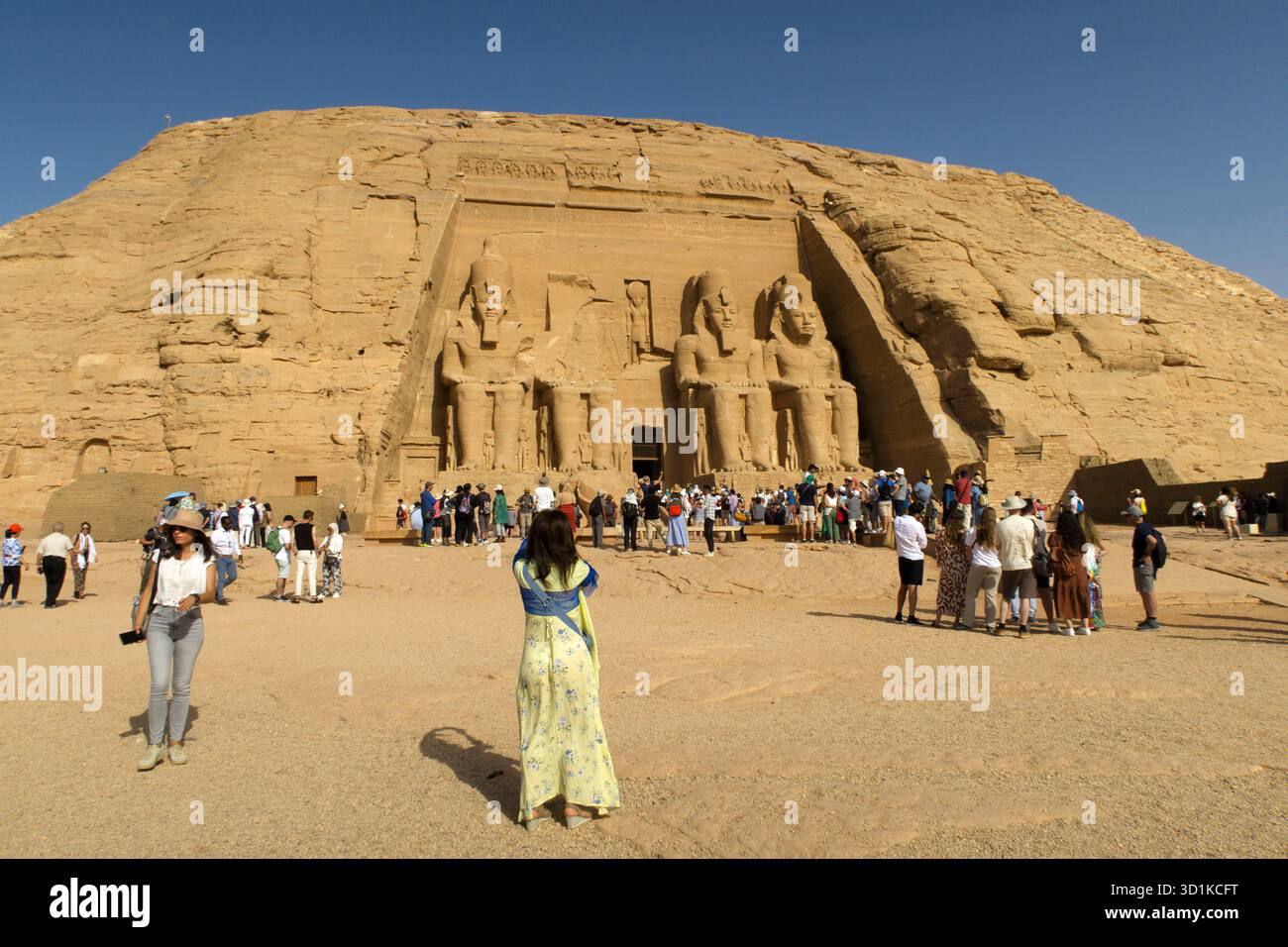 Touristes visitant les anciens temples d'Abu Simbel taillés dans la roche dans le désert avec des statues colossales sculptées dans la falaise de grès, en Égypte Banque D'Images