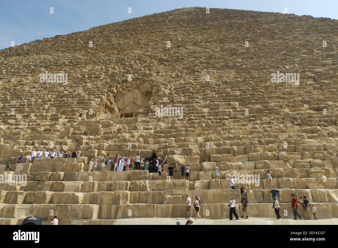 Touristes explorant et escaladant la Grande Pyramide de Gizeh par une journée ensoleillée en Egypte Banque D'Images