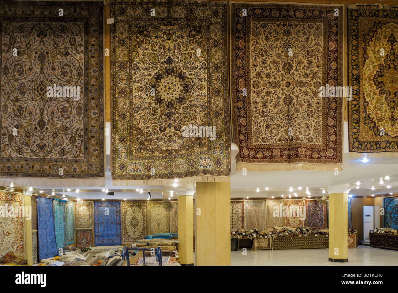 Intérieur d'un magasin de tapis avec un affichage de tapis traditionnels faits à la main accrochés aux murs et disposés sur le sol en Egypte Banque D'Images