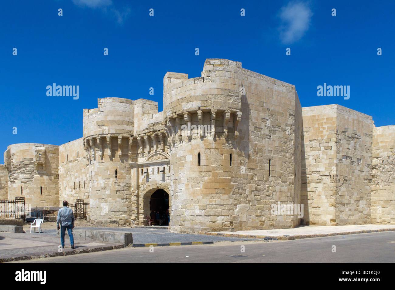 Homme debout près de l'entrée de la Citadelle de Qaitbay alias Fort de Qaitbay, une forteresse historique à Alexandrie, Egypte Banque D'Images
