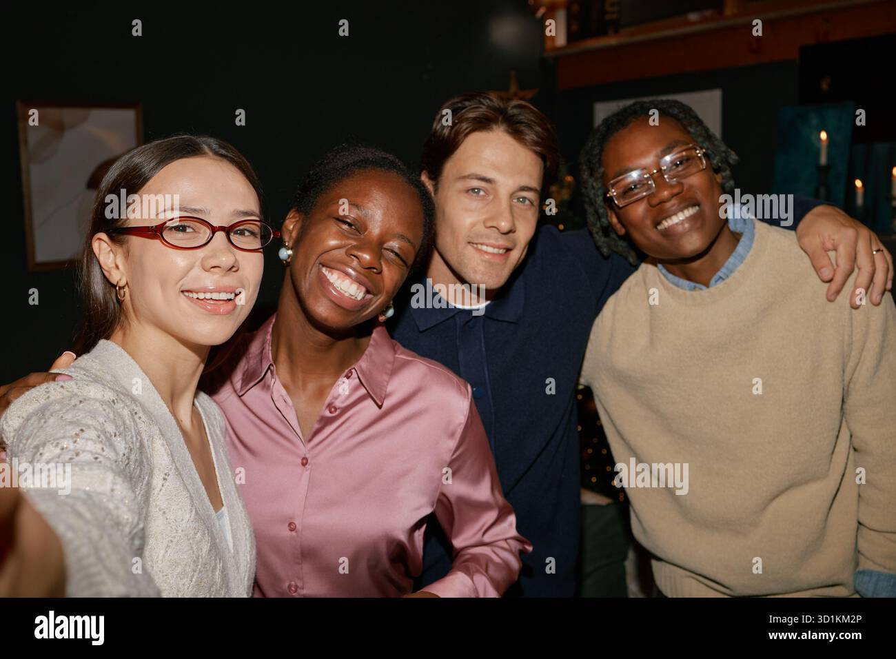 Groupe de jeunes amis multiethniques souriant et posant pour Selfie à l'intérieur Banque D'Images