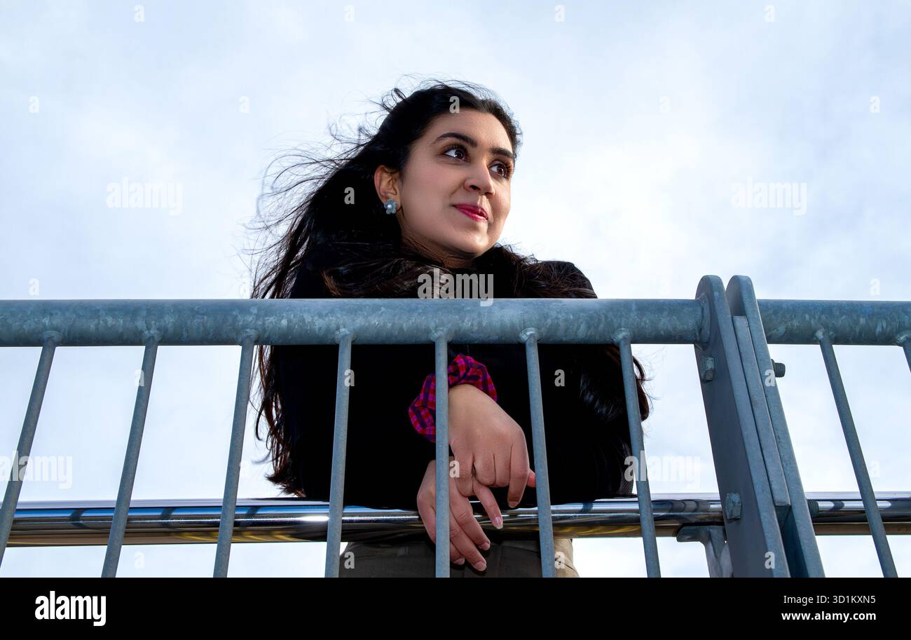 Le long de la rivière Dundee dans le soleil d'hiver une belle femme avec de longs cheveux bruns soufflant dans des rafales de vent, en Écosse Banque D'Images