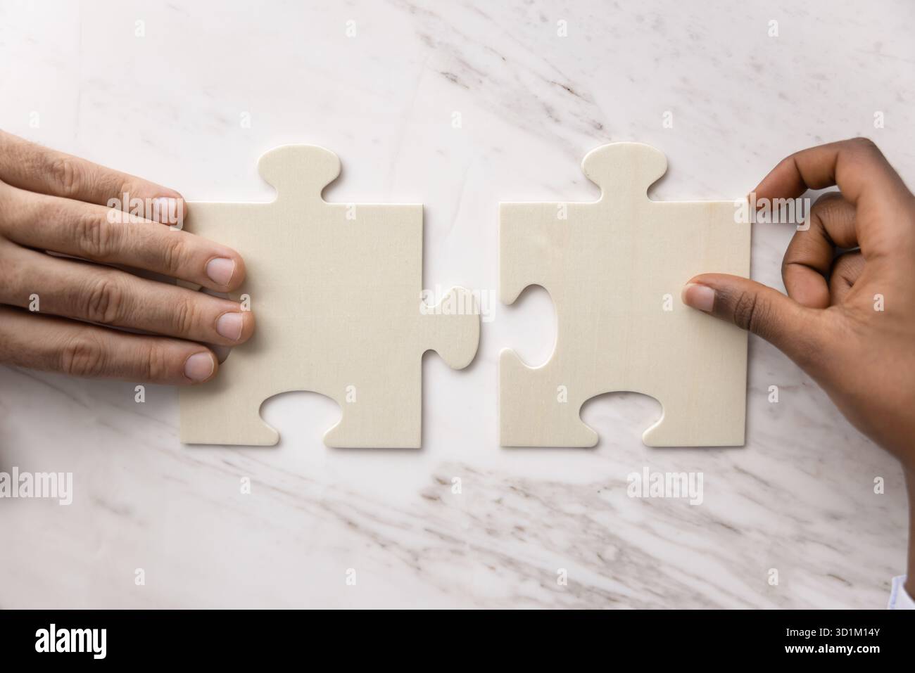 Mains de personnes de diverses ethnies correspondent puzzle sur le bureau Banque D'Images