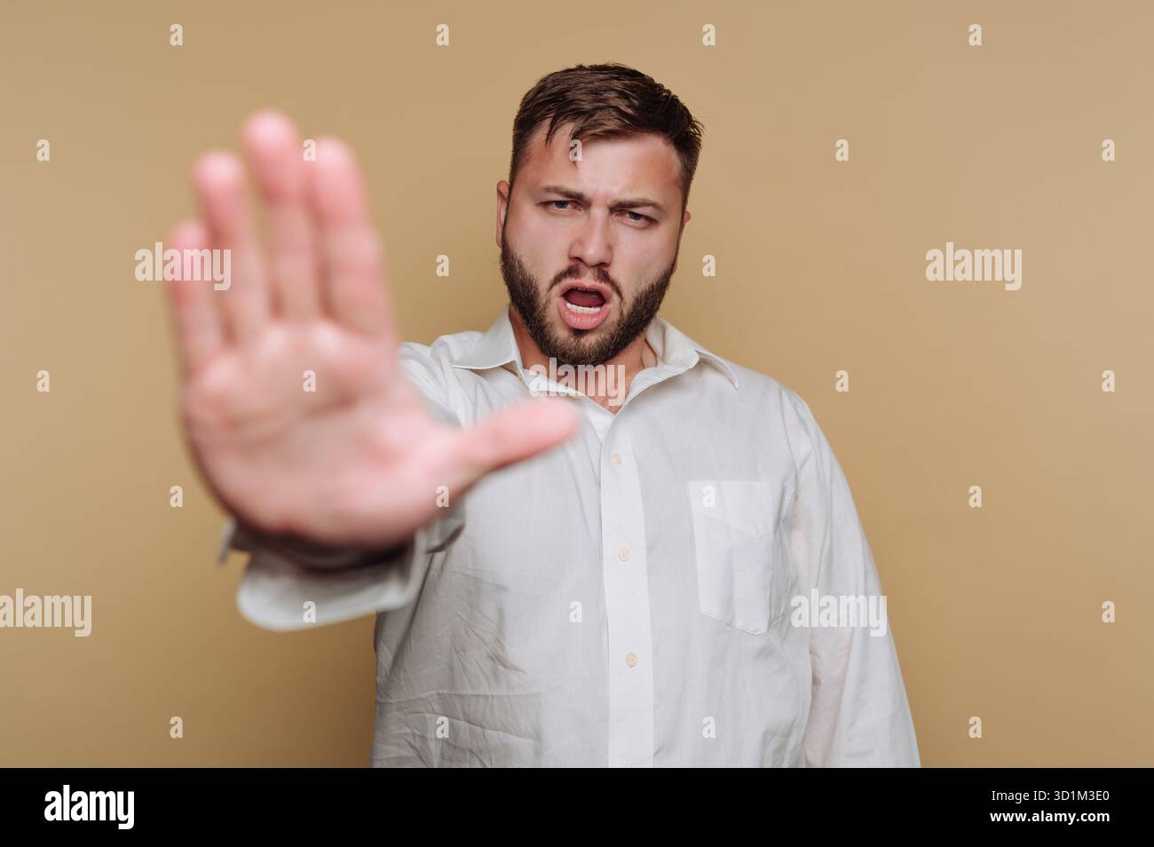 Homme en chemise blanche faisant un geste stop avec sa main. Banque D'Images