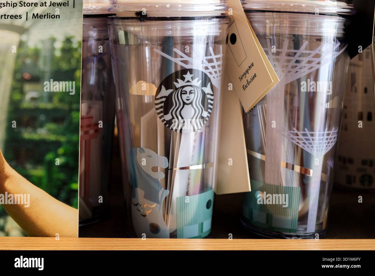 Exposition de tasses souvenirs colorées Starbucks à l'aéroport de Changi. Chaque tasse présente des monuments emblématiques de Singapour avec un design moderne et des couleurs vives. Banque D'Images