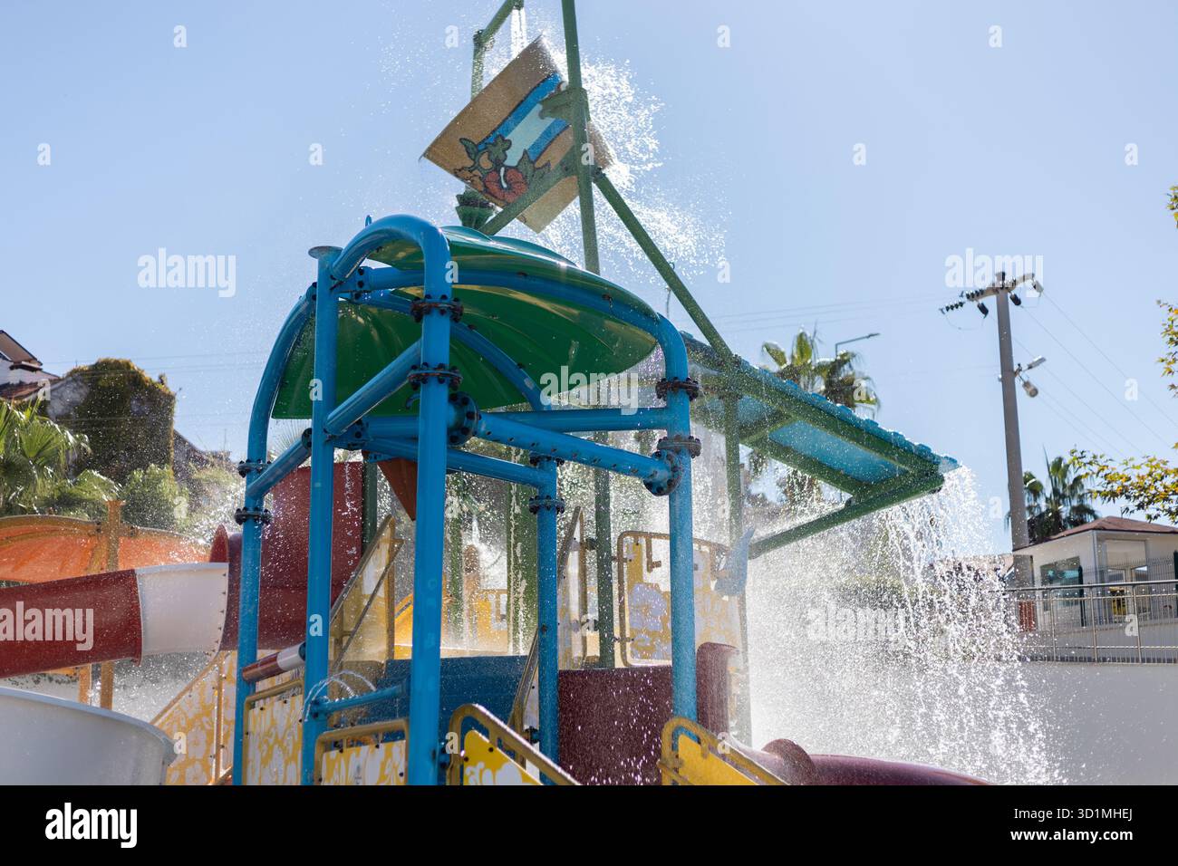 La structure de jeu aquatique présente des couleurs vives et de multiples toboggans, avec des éclaboussures d'eau partout pendant que les enfants profitent de leur temps au parc aquatique sur un Banque D'Images