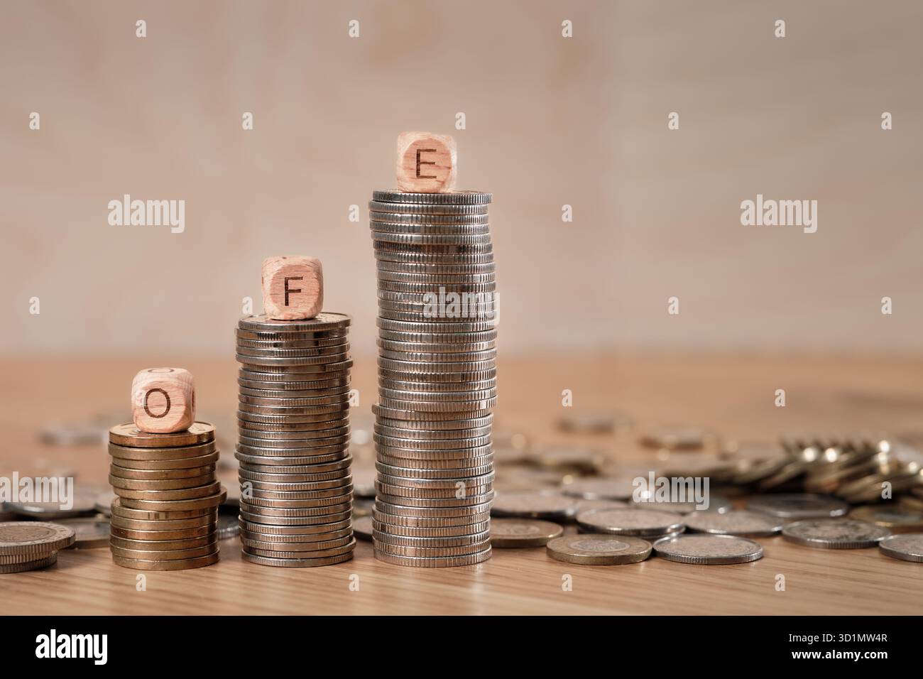 Cubes en bois avec lettres OFE (Open pension Fund â€“ Otwarty Fundusz Emerytalny) disposés sur des piles de pièces polonaises représentant l’épargne retraite et la croissance du capital. Banque D'Images