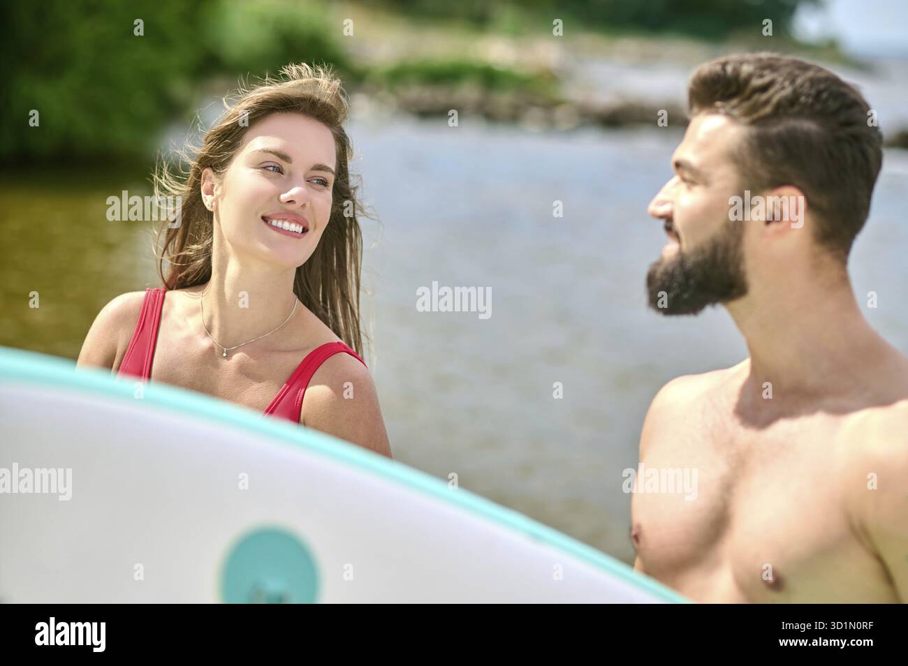 Romantique homme et femme jeunes surfeurs sur la plage, profiter de vacances près de la mer et le sport extrême, exprimant des émotions positives Banque D'Images