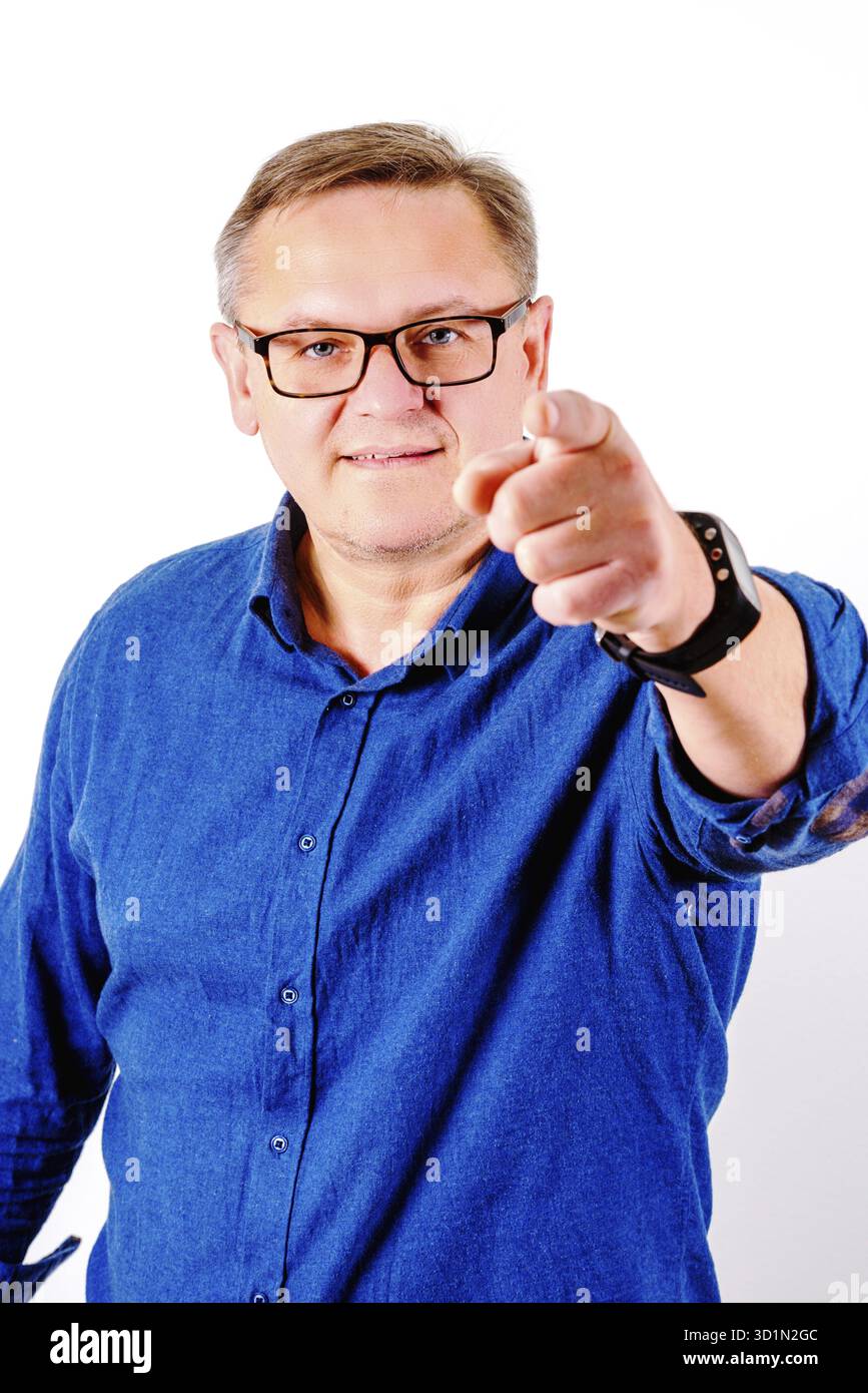 Pointant les hommes d'âge moyen dans des lunettes et chemise bleue Banque D'Images