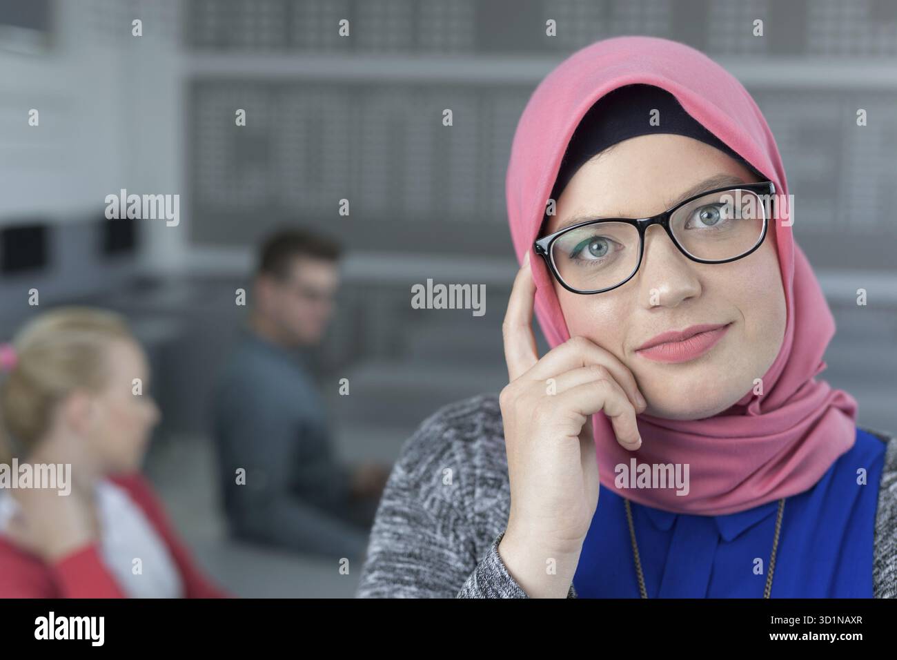 Jeune femme islamique avec un groupe d'élèves habillés de vêtements traditionnels à l'intérieur du cadre scolaire Banque D'Images