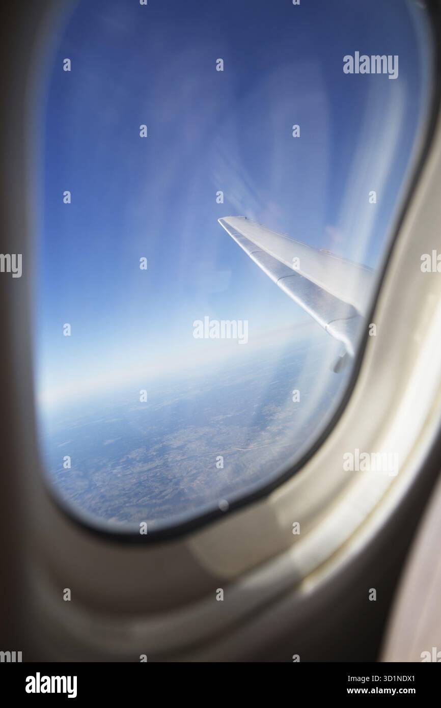 Terre, océan et aile d'avion vue depuis la fenêtre de l'avion Banque D'Images