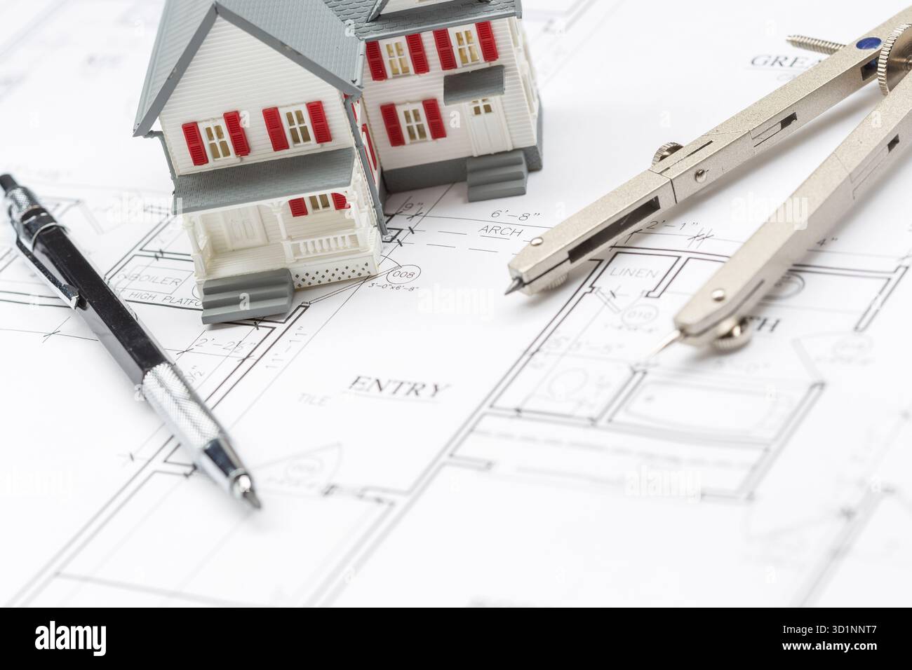 Maison modèle, crayon et boussole reposant sur des plans de maison Banque D'Images
