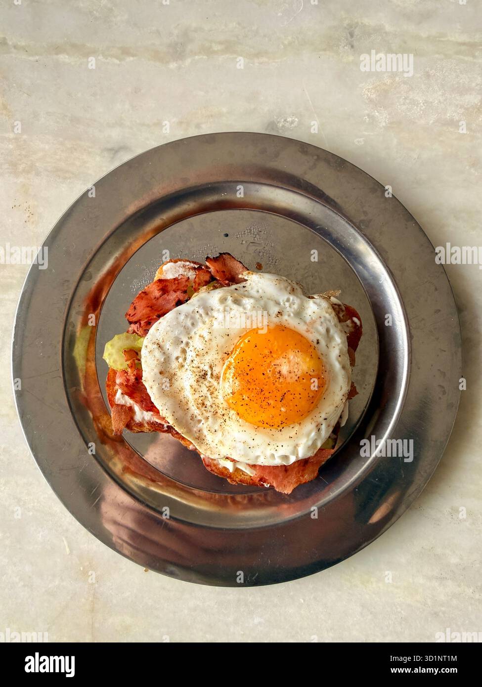 Sandwich aux œufs frits avec tomate et sésame noir sur une assiette en métal - Image de stock capturée avec un smartphone