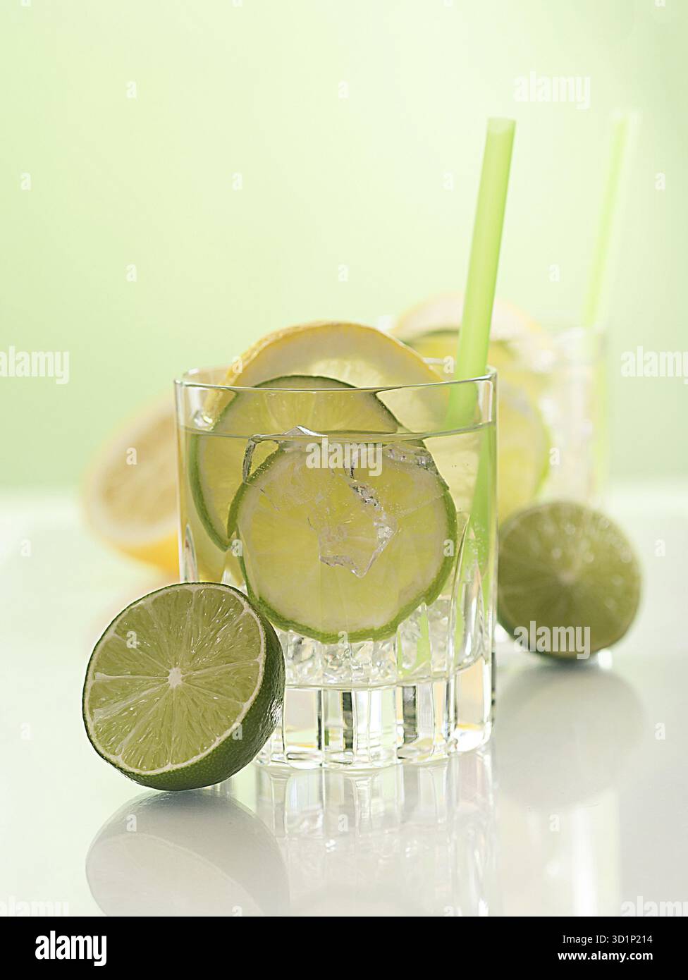 Cocktail avec citron vert, tranches de citron et glaçons Banque D'Images