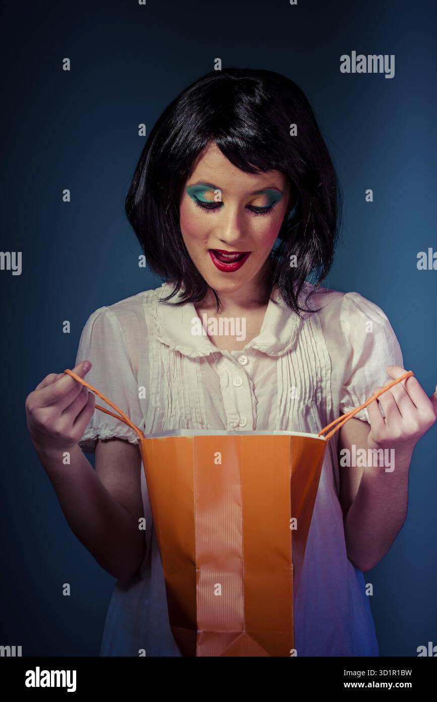 Surprise, Shopping teen avec un sac d'Orange sur bleu chroma Banque D'Images