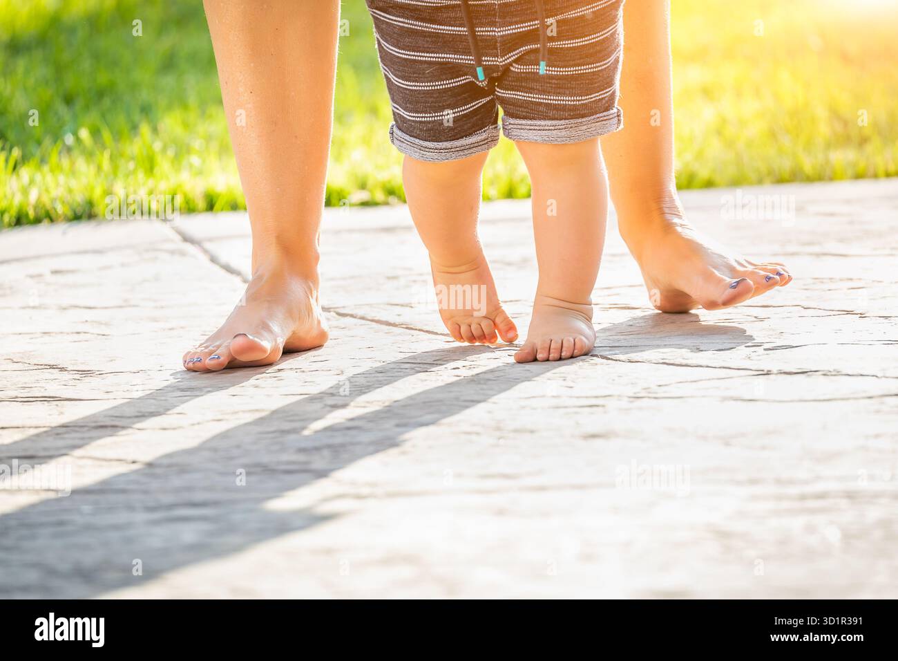 Mère et bébé pieds faisant des pas à l'extérieur Banque D'Images