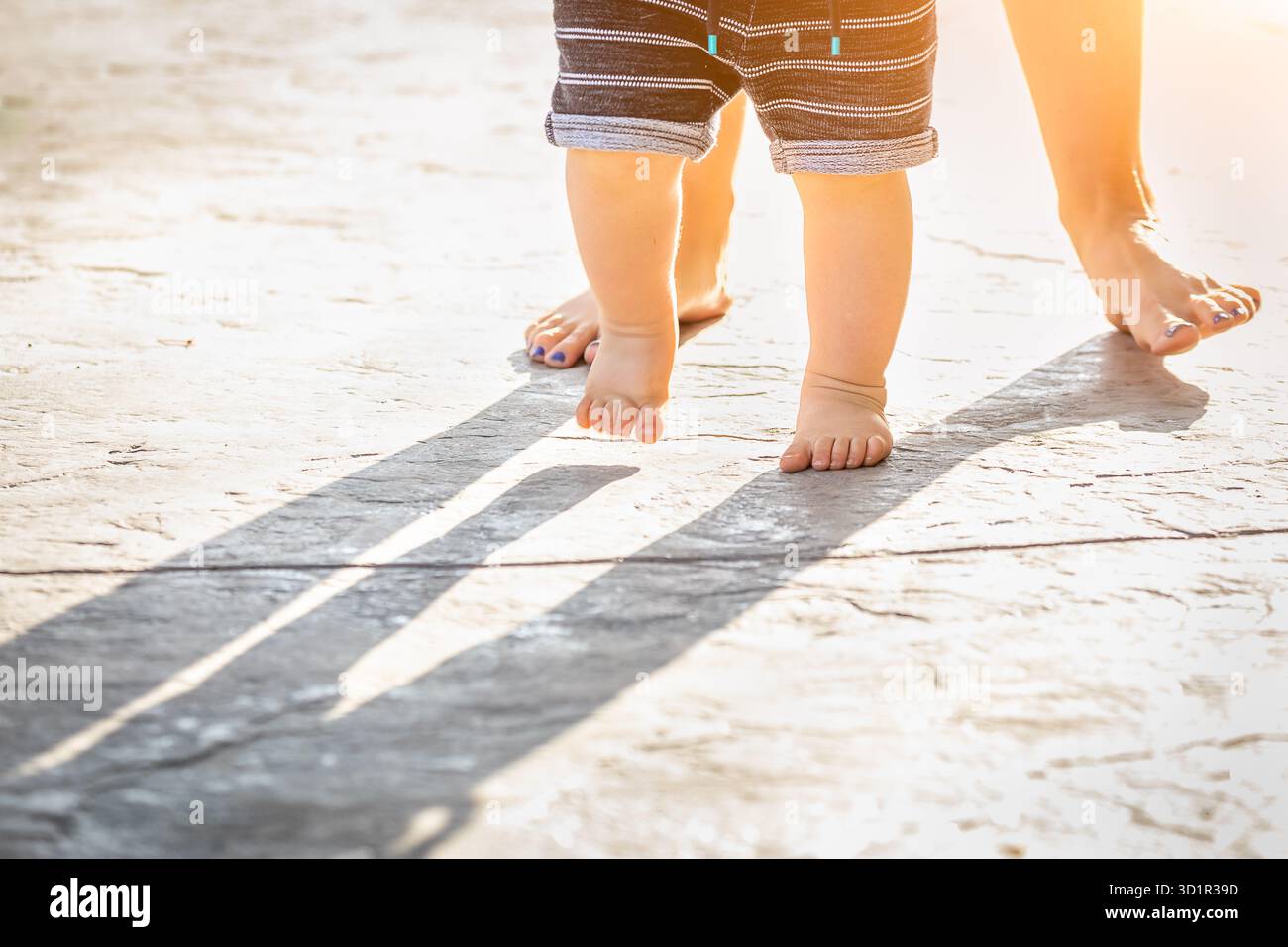 Mère et bébé pieds faisant des pas à l'extérieur Banque D'Images