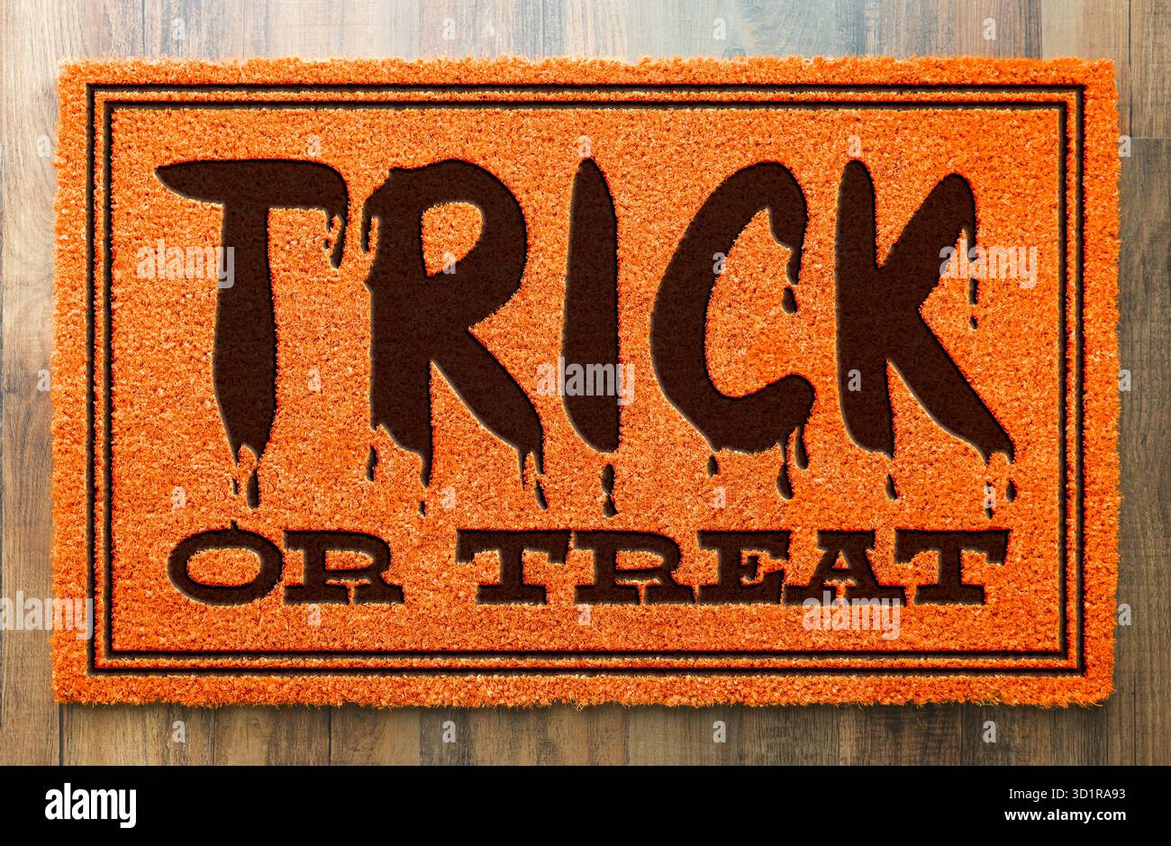 Trick or Treat Halloween Orange Welcome Mat sur fond de plancher de bois Banque D'Images