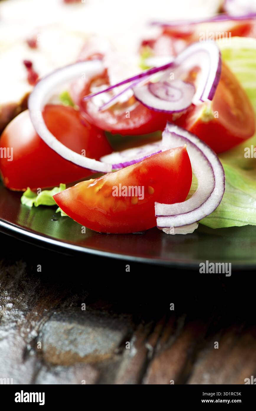 Salade de légumes dans une assiette sur une vieille table en bois Banque D'Images