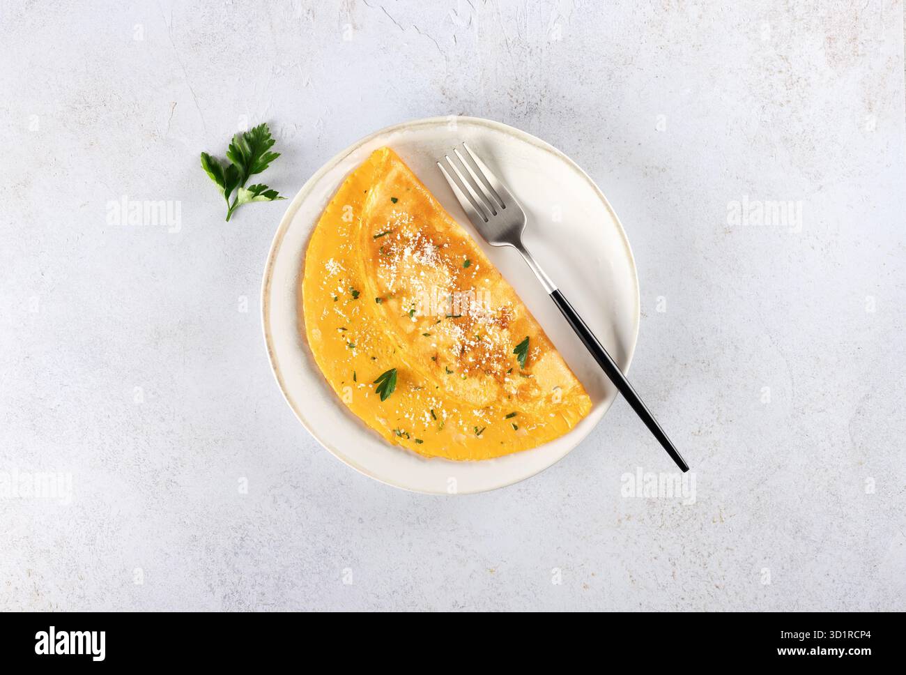 Omelette aux œufs avec fromage et persil sur fond blanc. Vue de dessus. Copier l'espace. Banque D'Images