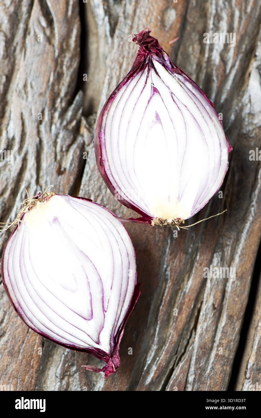 Oignons rouges frais sur une vieille table en bois Banque D'Images