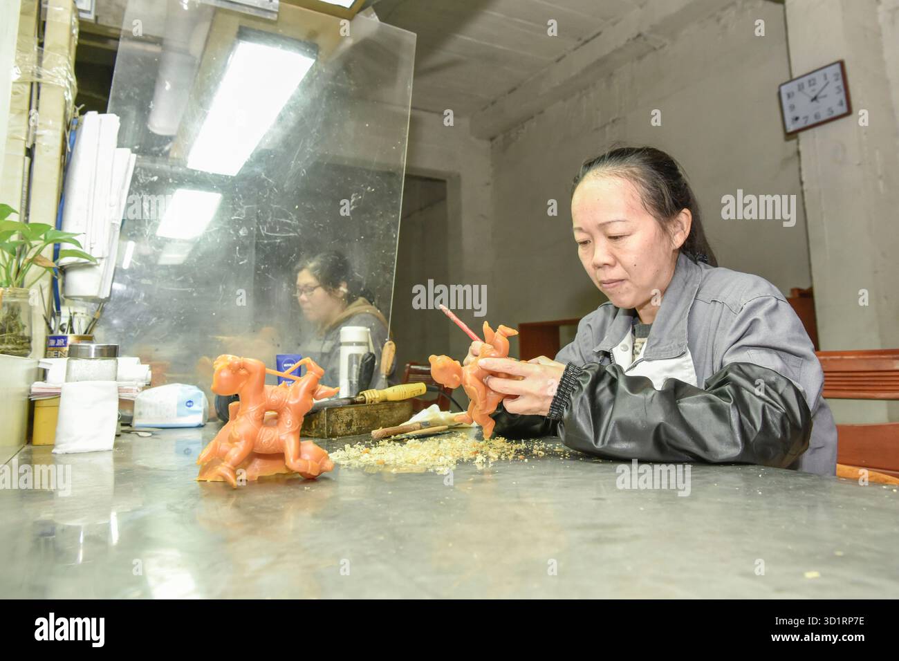 (251029) -- TONGLING, Oct. 29, 2025 (Xinhua) -- des ouvriers sculptent des modèles de cire dans une entreprise d'artisanat de bronze à Tongling, dans la province d'Anhui de l'est de la Chine, Oct. 29, 2025. La fonte à cire perdue est l'une des techniques les plus importantes de la fonte du bronze chinois antique, avec son histoire remontant à la période du printemps et de l'automne (770-476 av. J.-C.) et à la période des États belligérants (475-221 av. J.-C.). Le processus comprend plusieurs étapes, dont la sculpture du modèle, la fabrication du moule en cire, le déparaffinage et la cuisson, et enfin la coulée du bronze. Cette méthode est particulièrement adaptée à l'artisanat d'objets aux formes complexes. I Banque D'Images