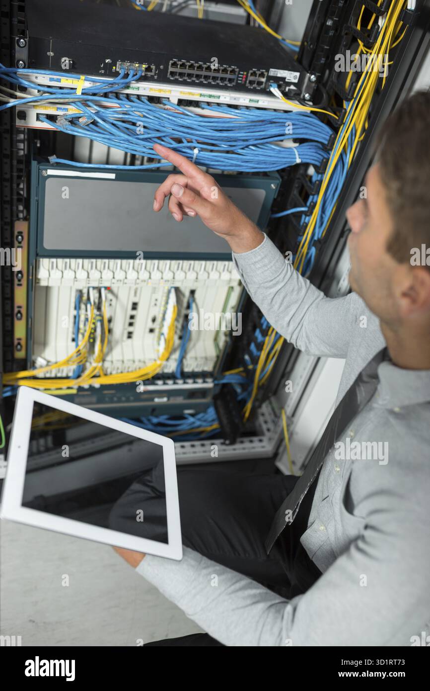 Jeune homme est debout à côté du châssis et l'équipement informatique Banque D'Images