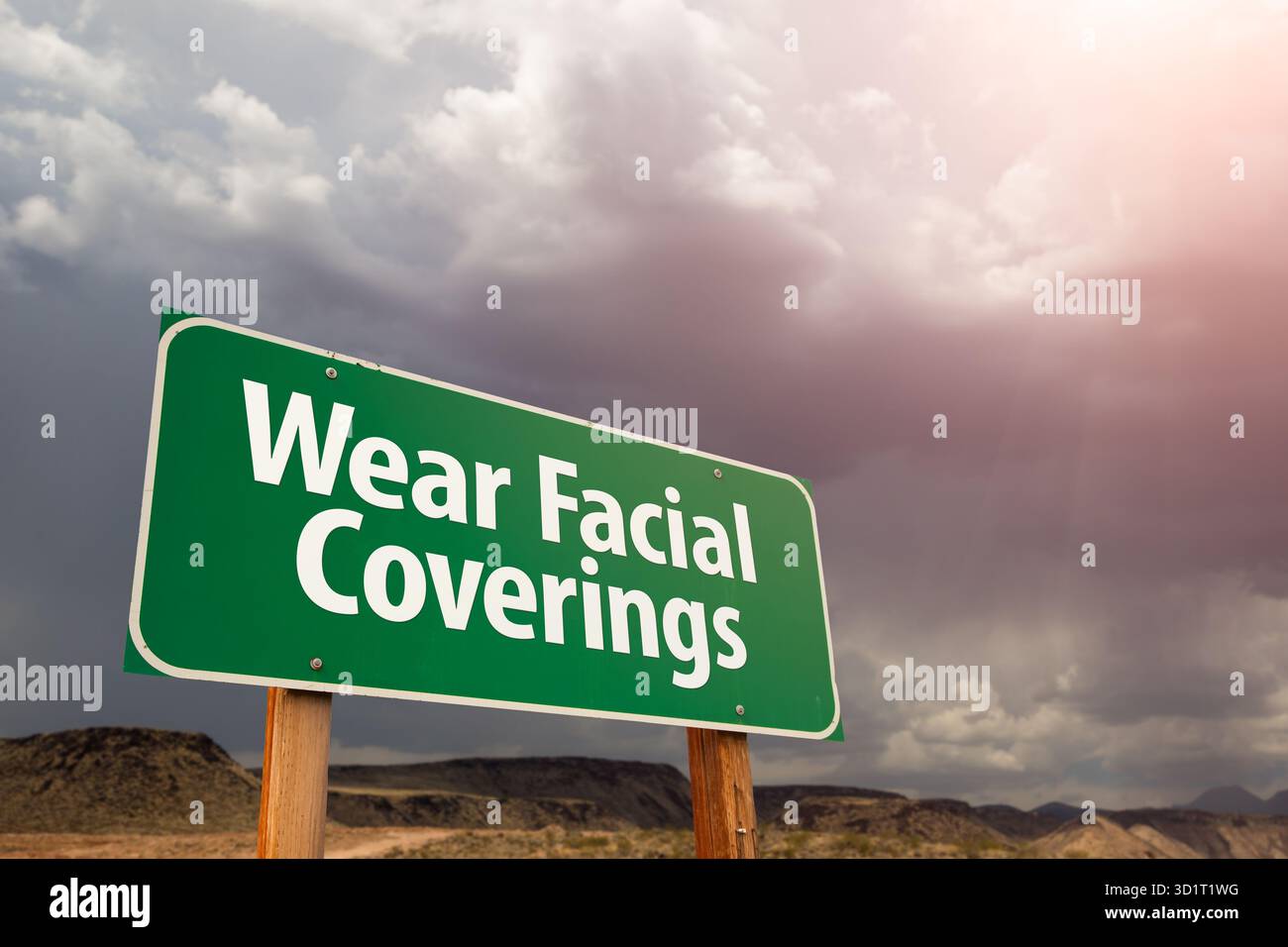 Portez des couvre-visage Green Road Sign Against Ominous Stormy Cloudy Sky Banque D'Images