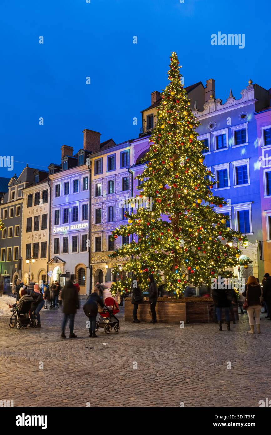 Varsovie, Pologne - 1er janvier 2022 : les gens à l'arbre de Noël sur la place du marché de la vieille ville pendant la saison des fêtes la nuit. Banque D'Images