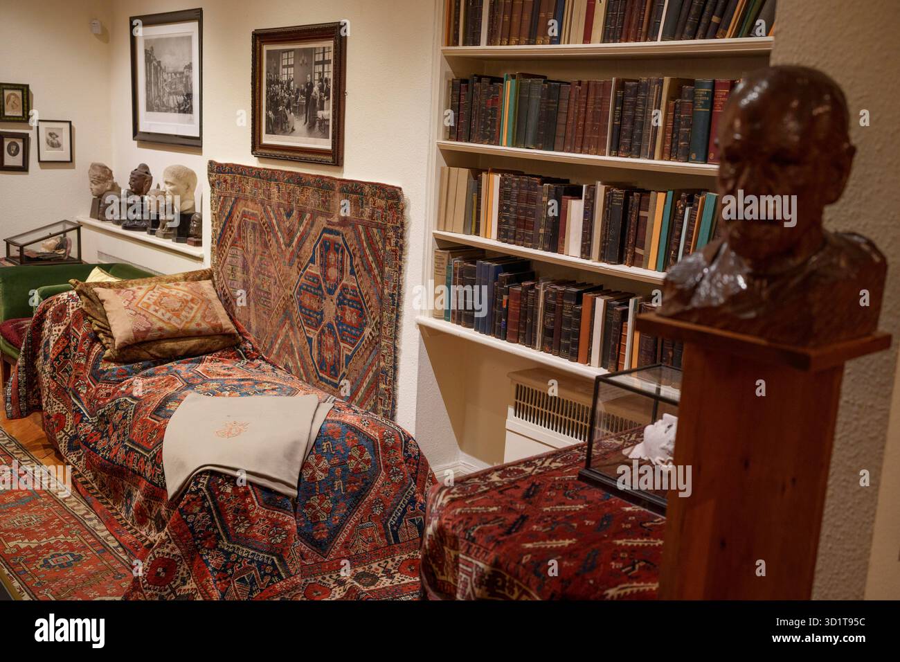 Buste en bois de Sigmund Freud et de son canapé psychanalytique dans son ancienne étude à sa maison du nord de Londres, le 29 octobre 2025, à Londres, en Angleterre. Psychanalyste Sigmund Freud (1865-1939) a vécu et travaillé ici au 20 Maresfield Gardens à Hampstead après avoir fui l'Autriche annexée aux nazis - mais après sa mort juste un an plus tard, c'est sa fille Anna Freud qui a continué à travailler ici en psychologie psychanalytique de l'enfant jusqu'à sa propre mort en 1982. Le musée Freud contient les archives Freud de livres et d'artefacts anciens des voyages de Sigmund Freud qu'il a pu apporter intacts quand Banque D'Images