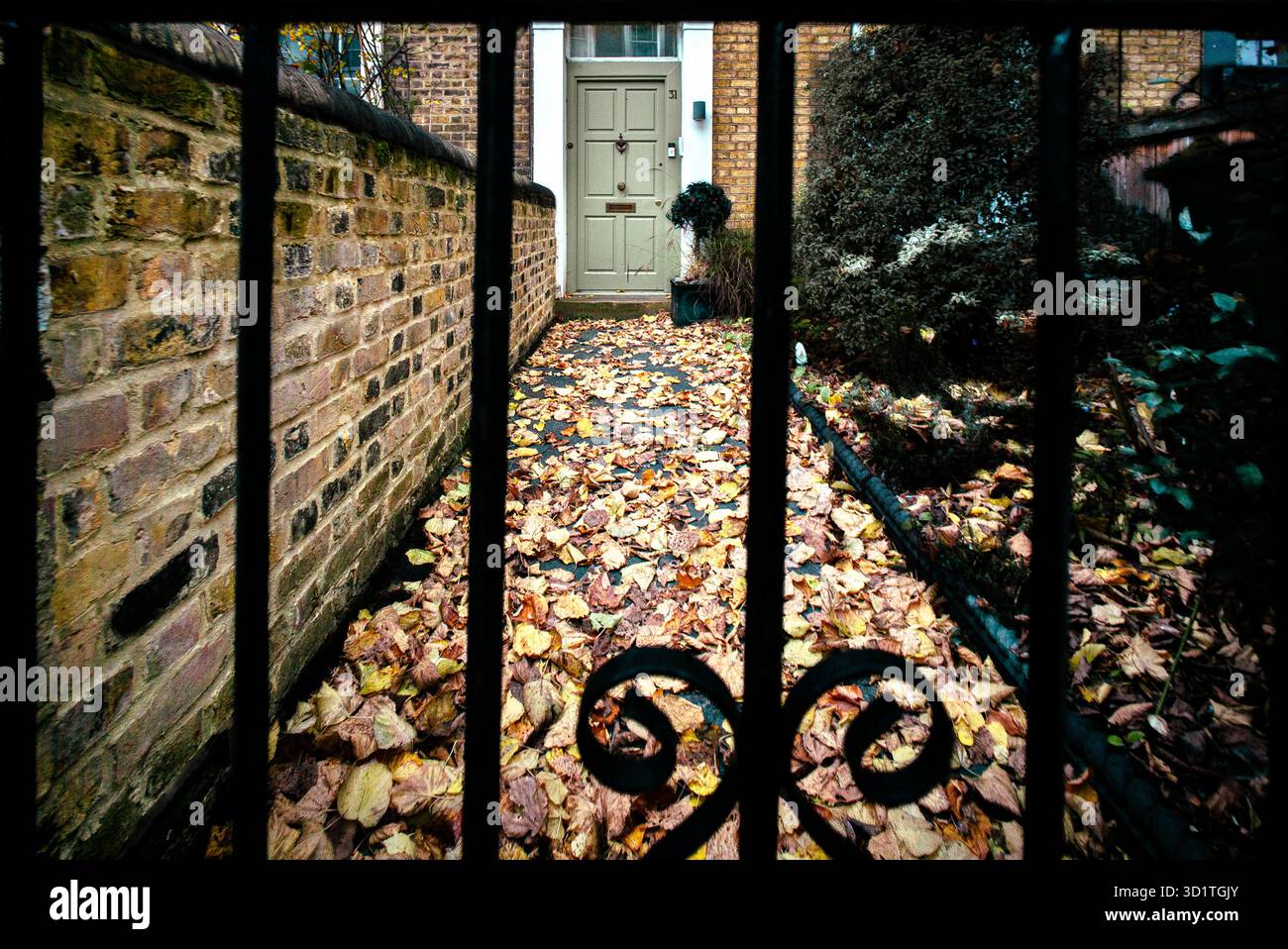 Feuilles d'automne sur le chemin de la porte d'entrée, vu à travers la porte Banque D'Images