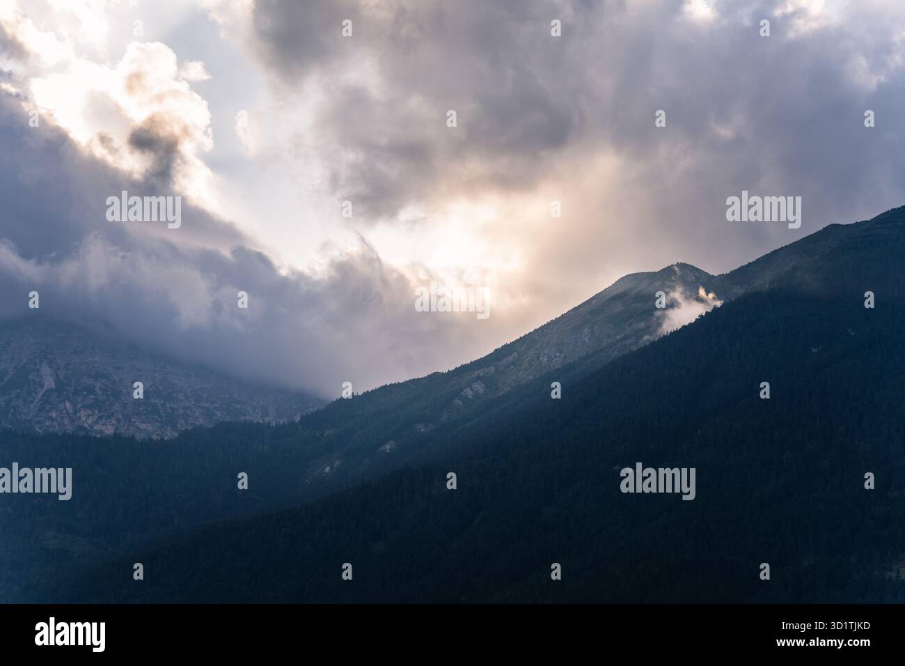 Spectaculaire lever de soleil nuageux sur la crête brumeuse des montagnes alpines Banque D'Images
