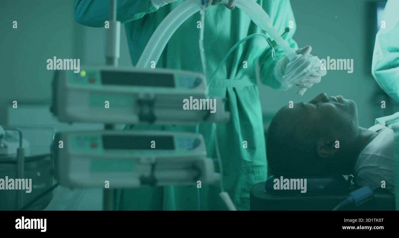 Anesthésiste dans les gommages tenant le masque d'anesthésie au-dessus du patient dans OU, avec les pompes à perfusion, copier l'espace Banque D'Images