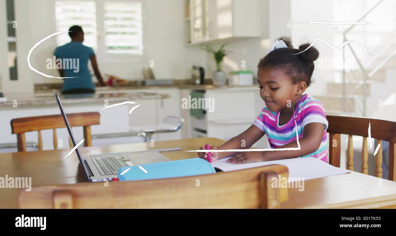 Fille de dessin tenant le marqueur rose à la table de cuisine familiale, avec ordinateur portable et étui à crayons, espace de copie Banque D'Images